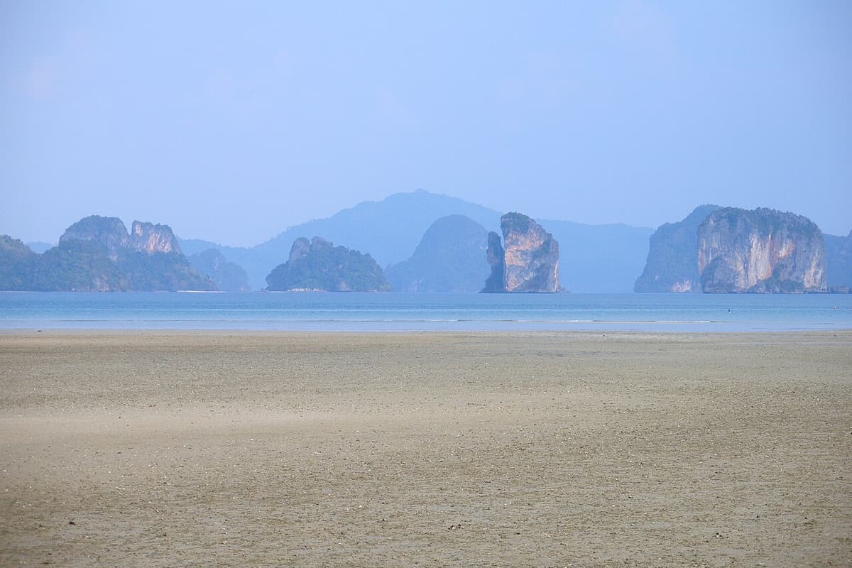 Limestone islands of Phang Nga Bay seen across calm water from Koh Yao Noi